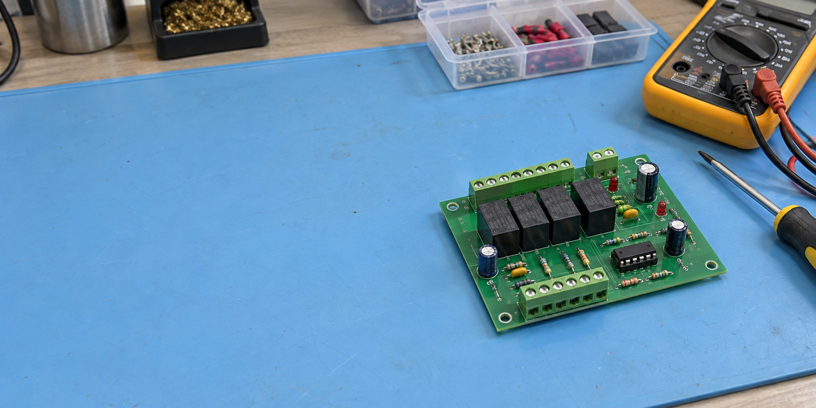 Illustrative repair bench with a relay control board and testing tools